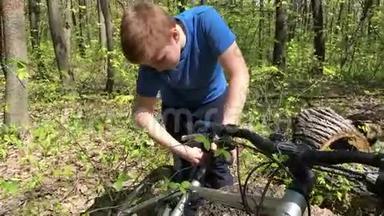 在树林里修自行车的男孩